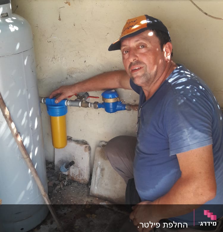 אדם בודק מסנן מים כחול וצהוב